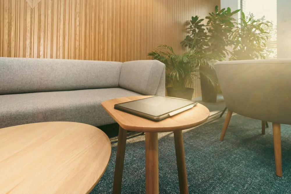 A warm, plant-filled commercial lounge in daylight